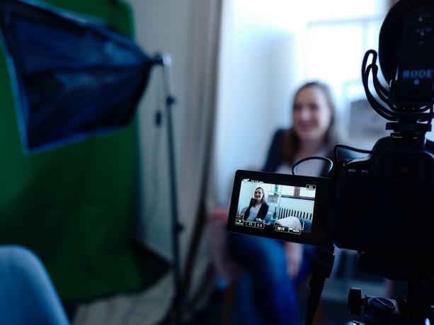 Black Video camera filming a woman