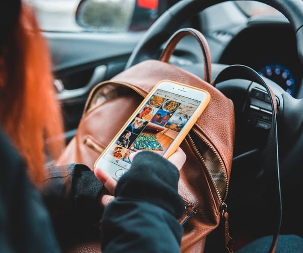 Girl with brown bag searching on her phone