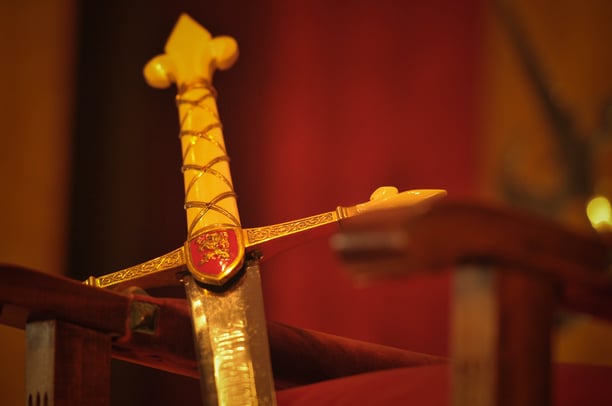 Gold sword on red textile