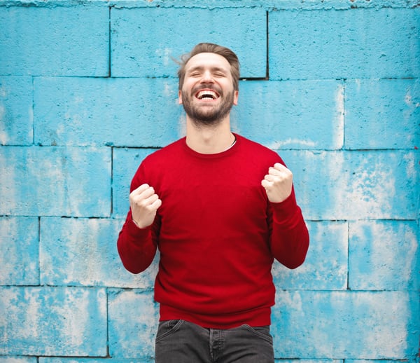 Happy person in front of blue wall