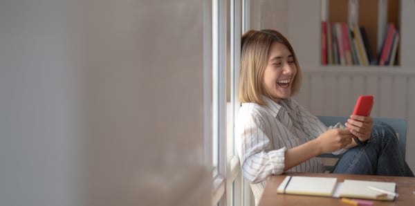 Happy woman laughing at smartphone