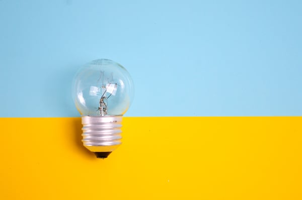 Light bulb on blue and yellow background