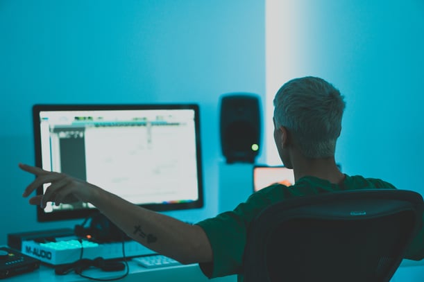 Man in green shirt sitting in front of the computer