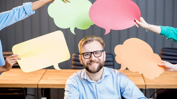 Man smiling surrounded by papers