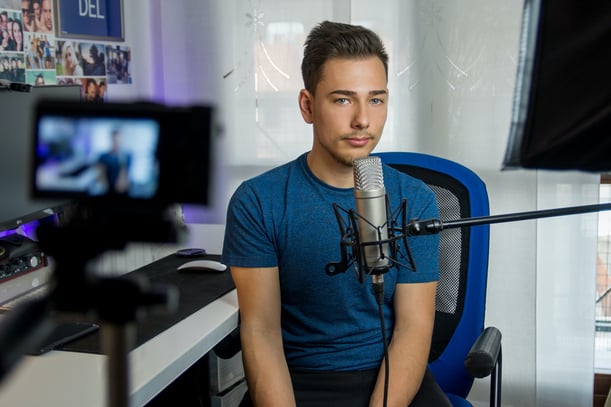 Man wearing blue tshirt sitting on blue chair