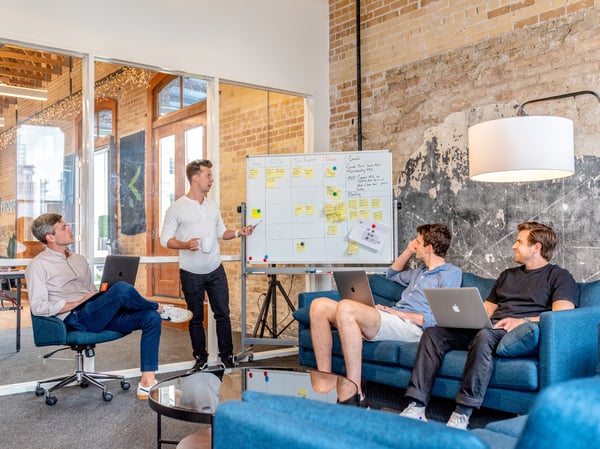 Men sitting around whiteboard