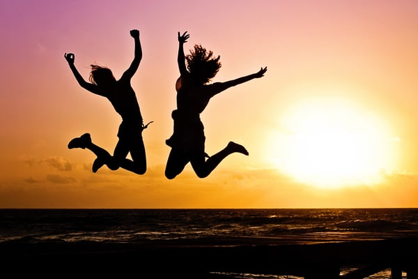 People jumping for joy in the sunset