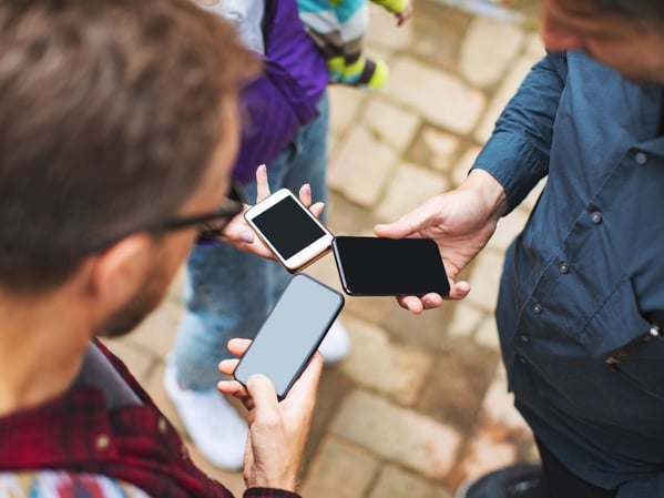 People staying in a circle with phones in hands