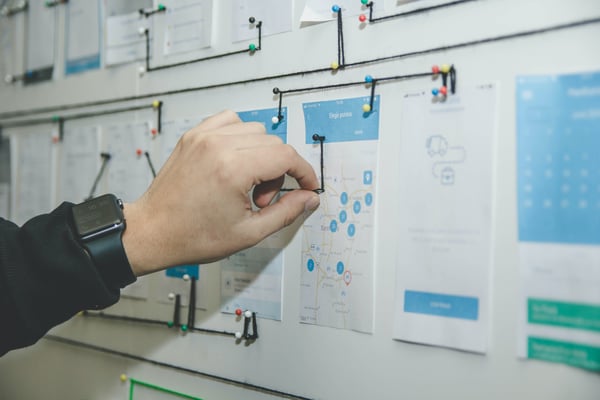 Person creating guidelines on wall with paper and string