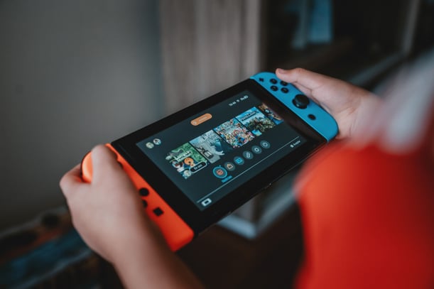 Person holding black and red nintendo