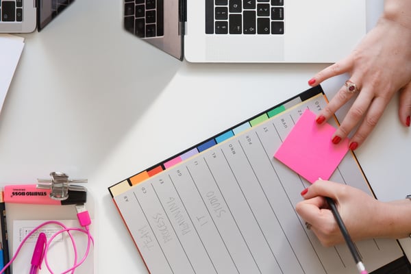 Person writing in planner