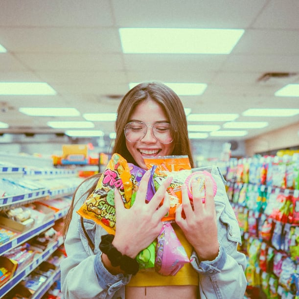 Smilling woman holding packs of candy