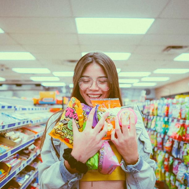 Smilling woman holding packs of candy