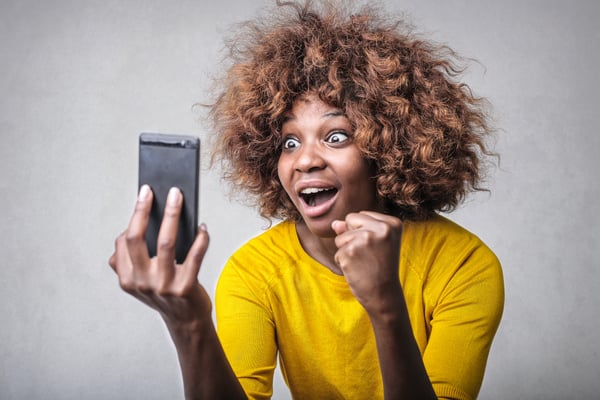 Surprised woman looking at smartphone