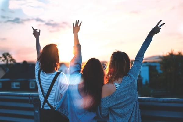 Three friendsraising their hands