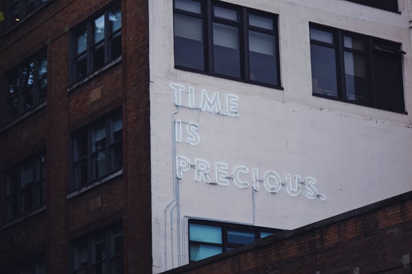 "Time is precious" neon sign on building