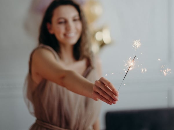 Woman keeping in hands sparkle firework