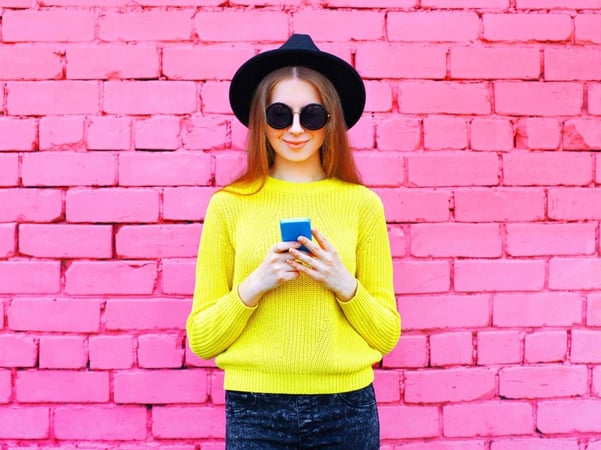 Woman standing in front of pink wall