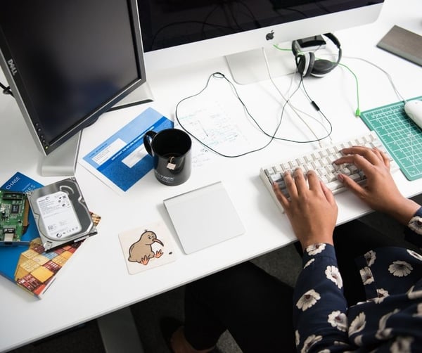 Woman typing on white keyboard