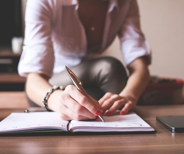 Woman with red nails writting