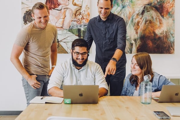 Working team member pointing to a laptop