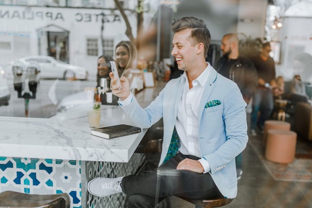 smiling man while looking at his phone